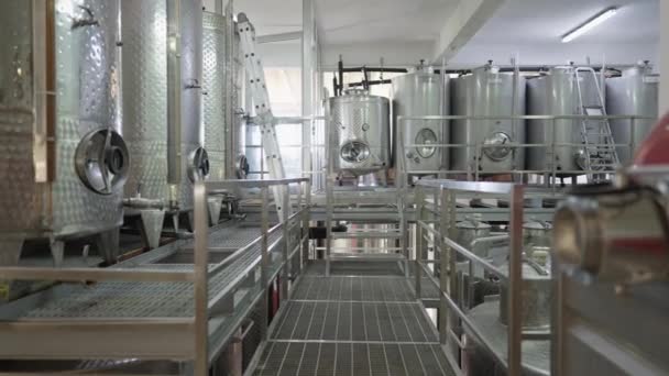 Interni ad ampio raggio della fabbrica di produzione di alcol all'interno. Righe di botti di vino in acciaio inox per la fermentazione delle bevande sull'impianto di produzione. Rallentatore. — Video Stock