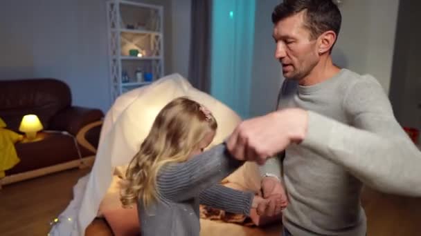 Handsome father spinning cute little daughter dancing in living room at home. Portrait of Caucasian man enjoying leisure with charming girl indoors on Fathers Day weekend. — Vídeo de stock