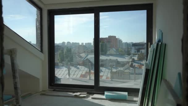 Широкий снимок большого окна в новом здании с Киевом Украина на заднем плане в солнечный день. Недвижимость в стадии строительства с городским городом на заднем плане. — стоковое видео
