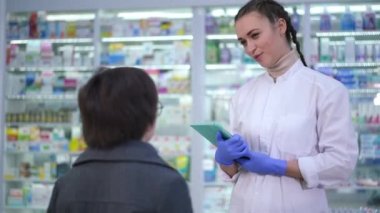 Genç pozitif eczacı, eczanede dikilen çocukla konuşuyor. Gülümseyen beyaz bir kadının portresi. Eczanedeki küçük müşteriye danışıyor..
