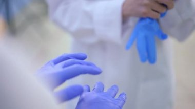 Yakından tanınmayan iki kadın doktor lastik eldiven takıyor. Beyaz kadınlar hastanede cerrahi ameliyata ya da tıbbi muayeneye hazırlanıyor..