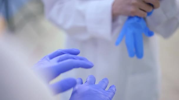 閉鎖2つの認識できない女性医師のゴム手袋を着る。病院内で手術や診察の準備をしている白人女性. — ストック動画
