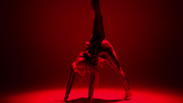 Wide shot sensual flexible woman dancing in red neon light bending doing back walkover looking at camera. Slim Caucasian performer posing moving on stage. Temptation and art concept. — Vídeo de Stock