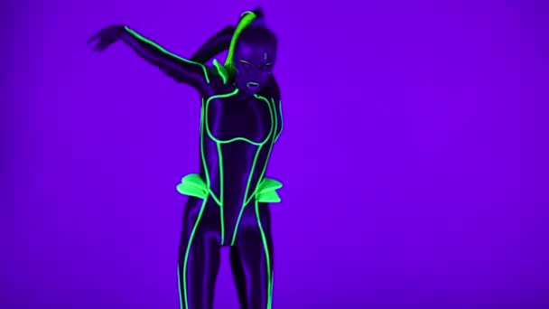 Front view portrait of confident woman in futuristic cyborg costume performing robot dance in ultraviolet light. Slim flexible dancer looking at camera moving bending lying down. — 비디오