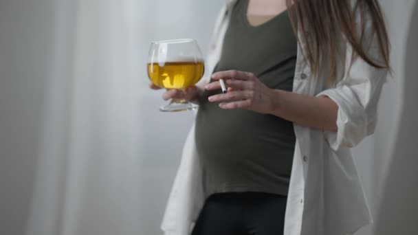 Неузнаваемая беременная женщина с сигаретой и пивом в помещении. Молодой худой европеец курит и пьет алкоголь во время беременности на третьем триместре. Концепция вредных привычек. — стоковое видео