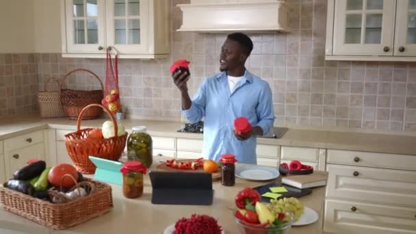 Homem afro-americano feliz escolhendo geléia caseira na cozinha sorrindo posando em casa. Câmera ao vivo zoom para cara confiante satisfeito gabando-se deliciosa sobremesa dentro de casa. — Vídeo de Stock