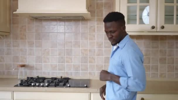 Plan d'un agriculteur afro-américain entrant dans la cuisine avec des légumes marinés en conserve. Sourire confiant jeune homme satisfait de la récolte à la maison à l'intérieur. — Video