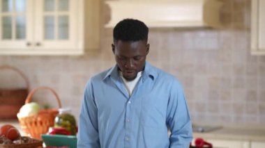 Omzunda önlük sallayan gururlu Afro-Amerikan adam gülümseyen kameraya bakıyor. Arka planda bulanık hasatla mutfakta poz veren kendinden emin mutlu erkek çiftçinin ön manzara portresi..