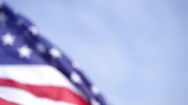 Açık havada mavi gökyüzünün arka planında dalgalanan yakın plan Amerikan bayrağı. Ulusal sembol yaz günü rüzgarla asılı..
