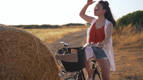 Joven mujer confiada con la mano en la frente mirando hacia otro lado de pie a la derecha en el campo rural en Chipre. Feliz campesina caucásica admirando la puesta de sol dorada al aire libre en cámara lenta. — Vídeos de Stock