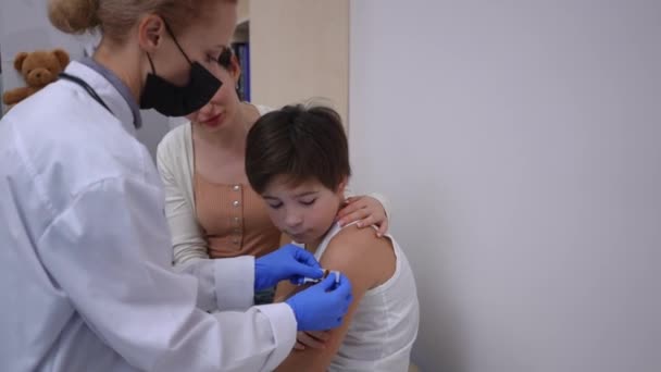 Live Camera Follows Positive Pediatrician Walking Boy Sticking Medical Patch — Stock Video