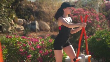 Kıbrıs 'ta güneşli bir günde merdivenlerde spor yapan genç ve zinde bir kadın. Kendine güvenen beyaz kadın sporcunun portresi yavaş çekimde gün ışığında antrenman yapıyor.