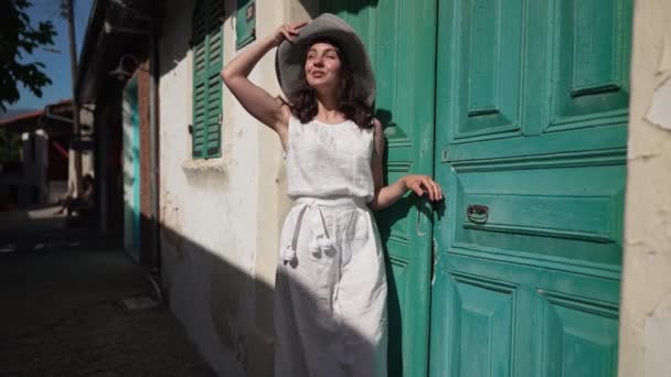 潘宁拍摄的照片中 一位自信的女性游客站在古城的街道上微笑着环视四周 在阳光明媚的夏日 在塞浦路斯的城市欣赏的快乐的白人年轻美丽女子的画像 — 图库视频影像