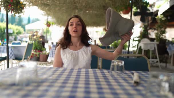 キプロスの熱帯歩道カフェに座ってファンの観光として藁帽子を振る疲れ若い女性 暑い夏の屋外で美しい女性の白人観光客の肖像画 — ストック動画