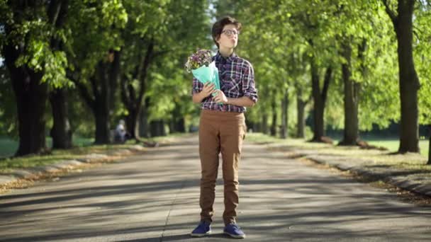 Широкий Выстрел Тревожный Подросток Букет Цветов Стоящих Солнечном Парке Глядя — стоковое видео