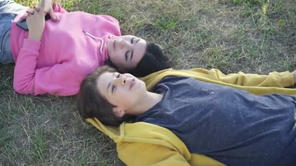 Top View Smiling Loving Teenage Boyfriend Girlfriend Lying Green Grass — Stock Video