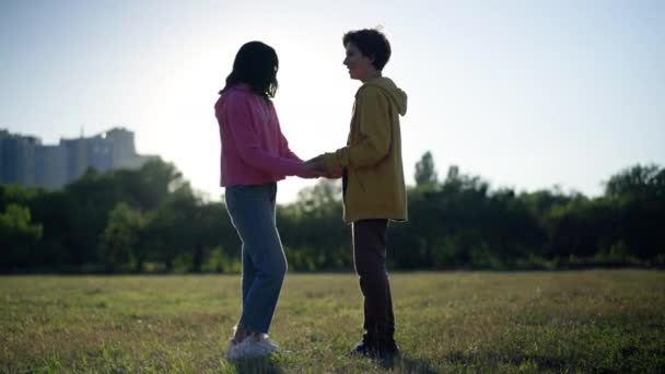 Side View Glad Teenager Par Holder Hænder Stående Solstråler Taler – Stock-video