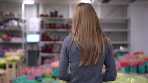 Achteraanzicht Slanke Jonge Vrouw Komt Bloemenwinkel Binnen Kijkt Rond Tracking — Stockvideo