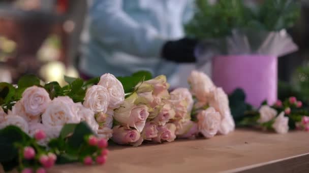 Fila Rosas Rosa Deitada Sobre Mesa Madeira Com Mulher Desfocada — Vídeo de Stock