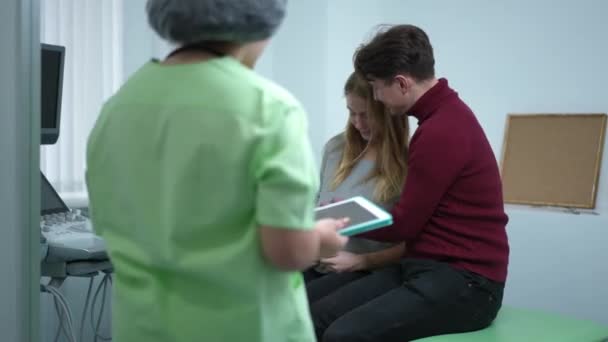 Pareja Feliz Hospital Con Obstetra Entrando Mostrando Ultrasonido Fetal Tableta — Vídeos de Stock