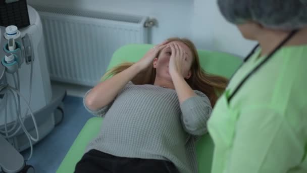 Hastanedeki Muayene Koltuğunda Uzanmış Elleri Ile Yüzünü Örten Hayal Kırıklığına — Stok video