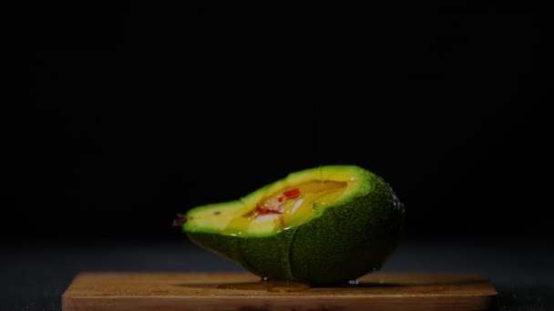 Olivenöl Auf Grüner Avocado Zeitlupe Auf Schwarzem Hintergrund Verteilen Bio — Stockvideo