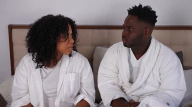 Rahatsız olmuş genç bir çiftin portresi. Kulaklarını kapatıp komşuların gürültüsünü dinliyor. Afro-Amerikalı yakışıklı adam ve güzel kadın evdeki yatak odasında.