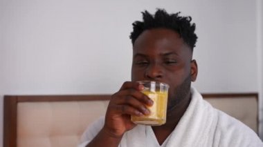Sabahları portre portresi çeken yakışıklı Afro-Amerikan bir adam. Rahatlamış, kendine güveni olan, düşünceli, düşünceli bir adam. Yatak odasındaki evde sağlıklı içkinin tadını çıkarıyor.