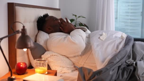 침대에서 한숨을 콧물이 흘러내리는 남자의 옆면에 보인다 추위와 독감을 아프리카 — 비디오