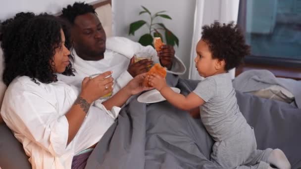 Feliz Madre Afroamericana Embarazada Padre Hablando Con Lindo Hijo Bebiendo — Vídeo de stock