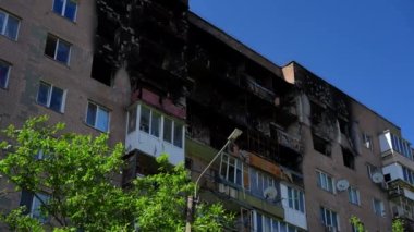 Kyiv Ukrayna 'da bombalanmış bir binada yanmış katlar. Güneşli bir yaz gününde, harap olmuş çok katlı bir binanın dış görüntüsü. Savaş ve yıkım kavramı