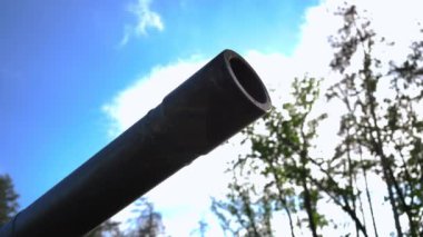 Close-up tank muzzle at background of sunny summer sky outdoors. Military vehicle part in sunshine in Ukraine. War defense and hope