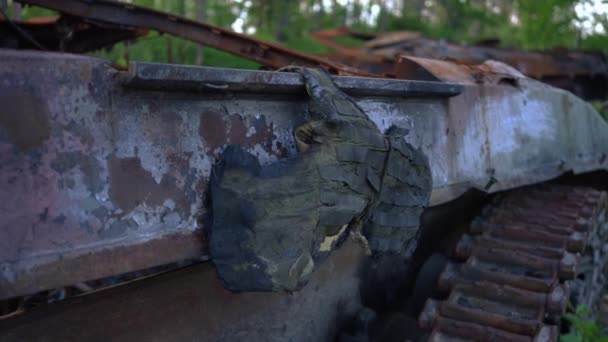 破壊されたタンクの屋外にぶら下がっている軍用ボディアーマーを焼きます ウクライナの戦争地帯における防弾ベストの残り物 — ストック動画