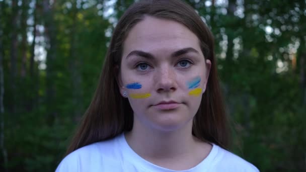 Фото Молодой Брюнетки Украинки Синими Желтыми Полосками Лице Смотрящей Камеру — стоковое видео