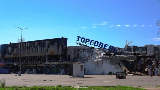 Kuraine Kyiv 2022年6月1日 キエフのショッピングセンターの廃墟を焼き 人々はスローモーションで歩いています ヨーロッパの首都でショッピングモールの破壊された外観のワイドショット — ストック動画