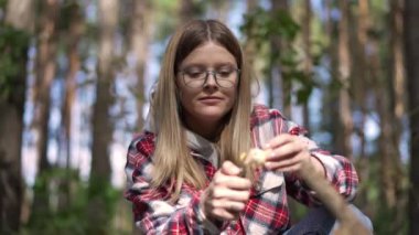 Açık havada güneşli ormanda ateş yakan genç bir kadının portresi. Kafkas kadın gezginin orman evinde şenlik ateşi yakarken ön görüntüsü. Kamp ve eko-turizm