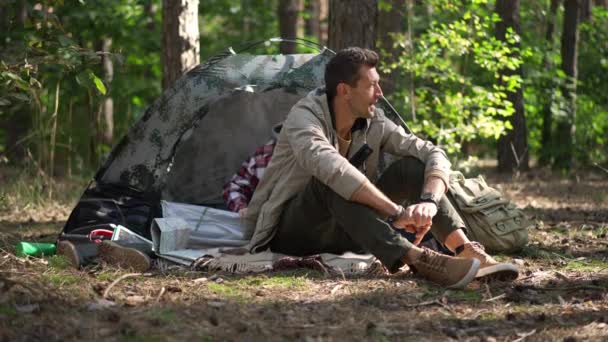 Уверенный Улыбающийся Мужчина Сидящий Лучах Солнца Лесу Женщина Выходящая Палатки — стоковое видео