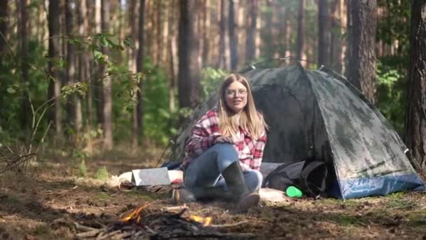 一位迷人的年轻女子的画像 她叫狗坐在森林帐篷篝火边 快乐的美国斯塔福德郡 Staffordshire 特里耶 Terrier 慢动作地跑向高加索旅行者摇着尾巴 — 图库视频影像