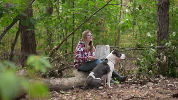 侧视自信的女人在森林里查看地图 对着狗说话 指指点点 带着宠物慢动作离开 美丽的高加索游客与美国斯塔福德郡的全景肖像画 — 图库视频影像