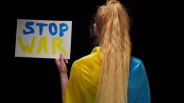 Mavi ve sarı Ukrayna bayraklı kadın savaş bayrağını gösteriyor. Siyah arka planda pankartla poz veren genç, sıska bayan destek ve yardım istiyor.
