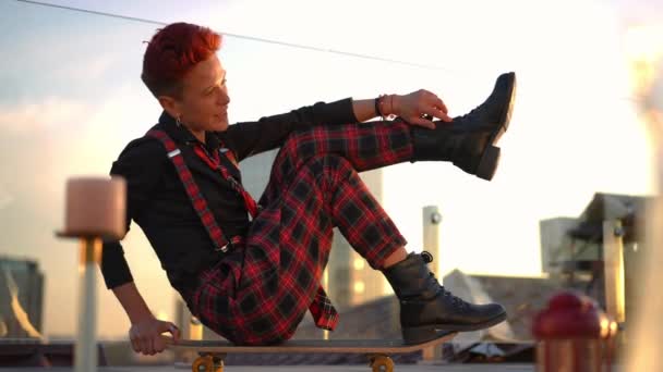 Carefree Caucasian Redhead Pierced Woman Sitting Skateboard Looking Camera Stretching — Stockvideo