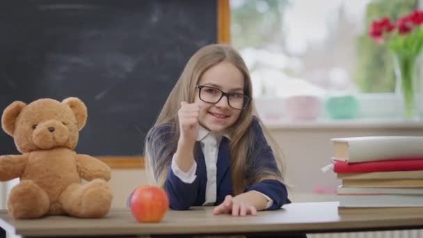 Pewna Siebie Uczennica Gestykulująca Kciukiem Górę Patrząc Kamerę Siedzącą Klasie — Wideo stockowe