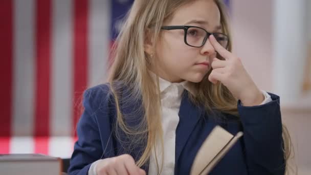 Teen Schoolgirl Adjusting Eyeglasses Reading Book Sitting Desk Classroom Portrait — Stock Video