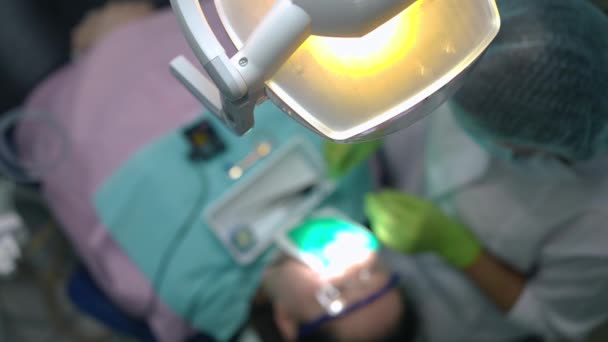 Високий Кут Огляду Стоматологічної Лампи Розмитим Лікарем Пацієнтом Задньому Плані — стокове відео