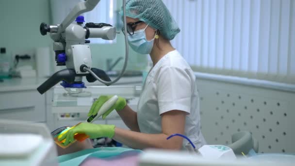 Vista Lateral Assistente Odontológico Concentrado Usando Luz Cura Para Polimerização — Vídeo de Stock