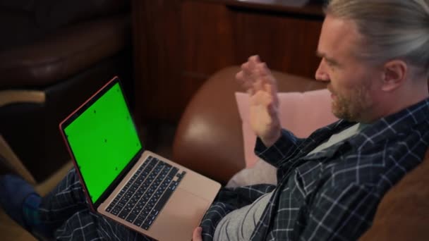 Laptop Mit Grünem Bildschirm Und Mann Der Schlafanzug Auf Der — Stockvideo