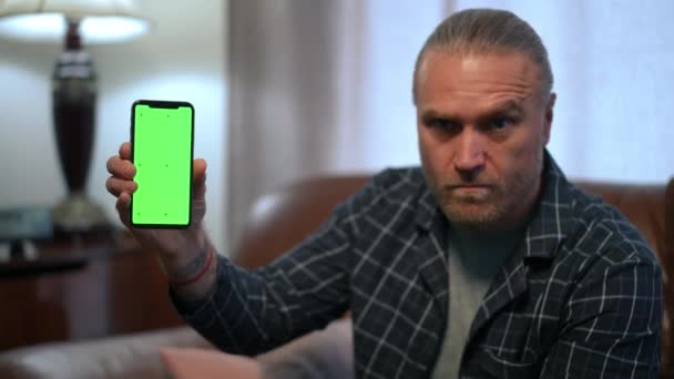 Bulanık Beyaz Adamın Elindeki Yeşil Ekranlı Telefon Kapalı Alanda Oturma — Stok video