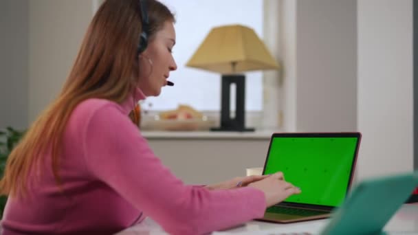 Okos Fiatal Szabadúszó Fejhallgató Beszél Gépelés Zöld Képernyős Laptop Billentyűzet — Stock videók
