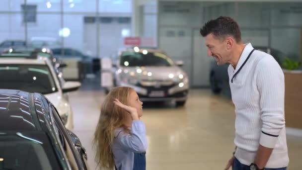 Laughing Father Daughter Gesturing High Five Standing Car Dealership Indoors — Vídeos de Stock