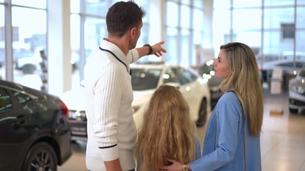 Back View Caucasian Man Woman Girl Standing Car Dealership Choosing — ストック動画